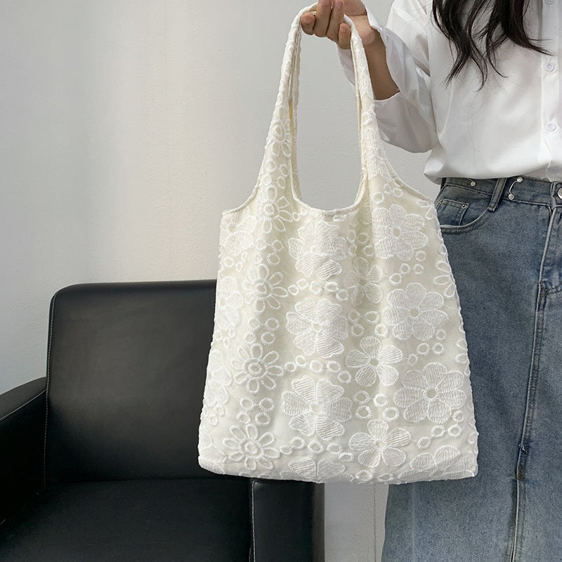 Ivory Eyelet Tote — worn or held by a model, supplier photograph