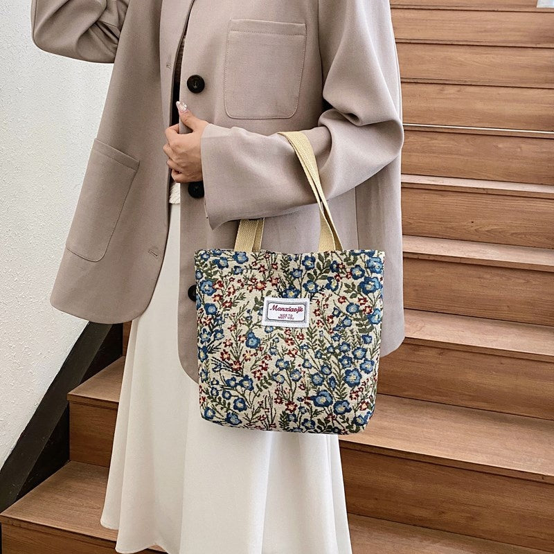 Ditsy Garden Zip Tote — worn or held by a model, supplier photograph